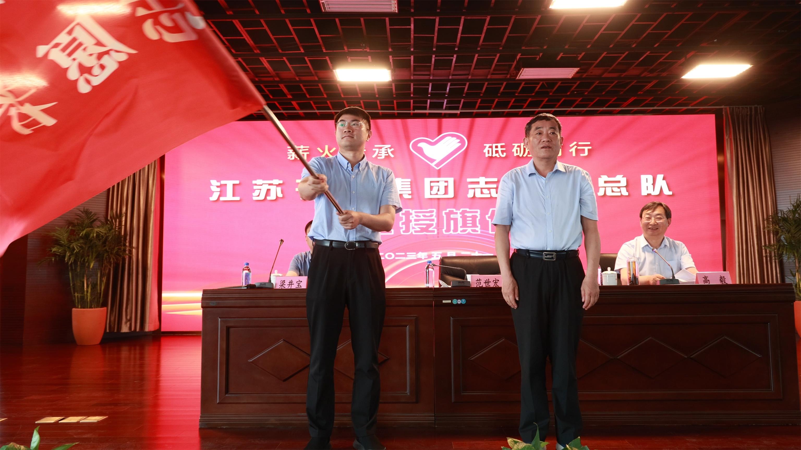 图1-3、范世宏董事长为邗建志愿者总队授旗.jpg